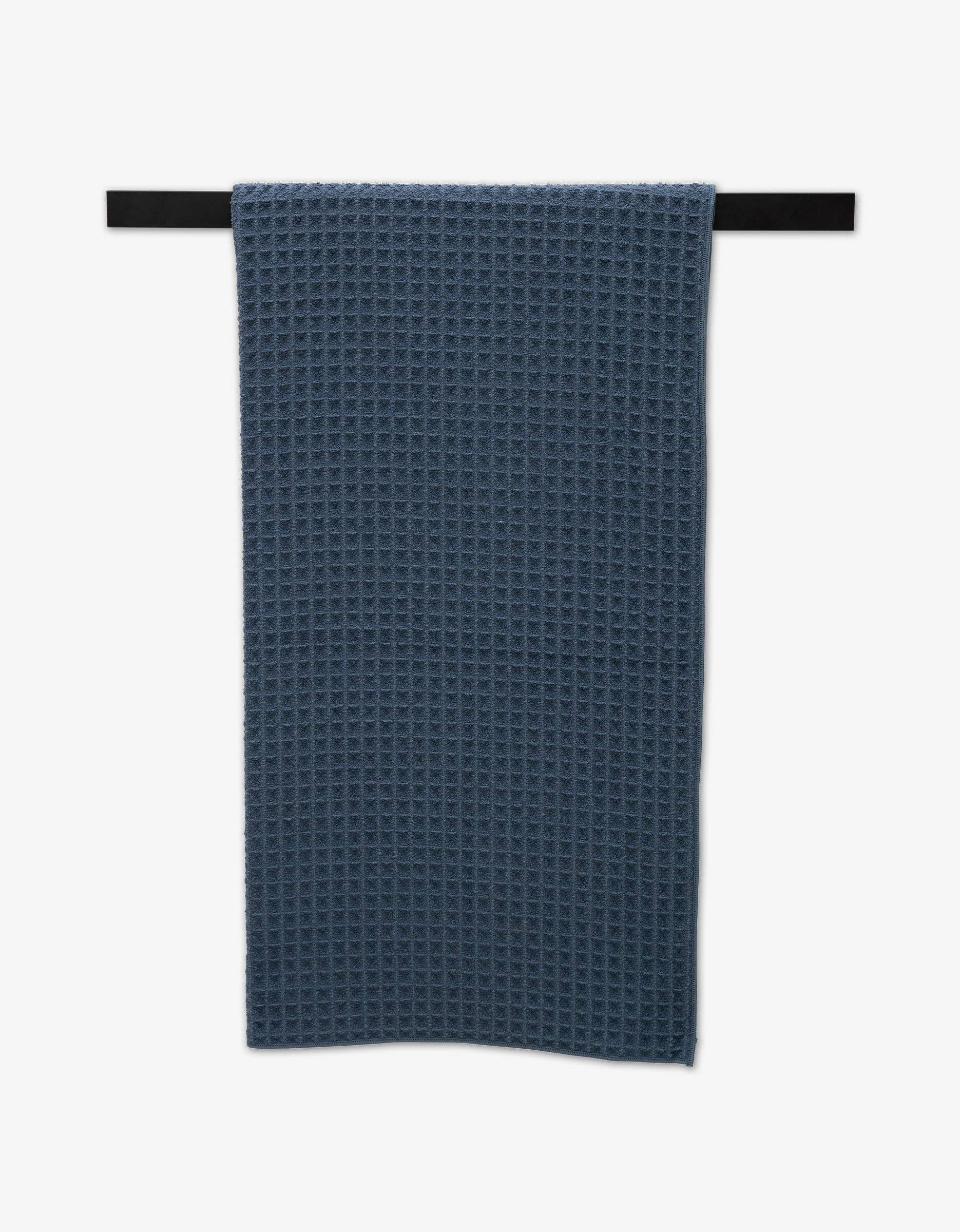 Geometry Waffle Bath Towel Midnight Blue  waffle-textured towel hanging on a black rod against a white background