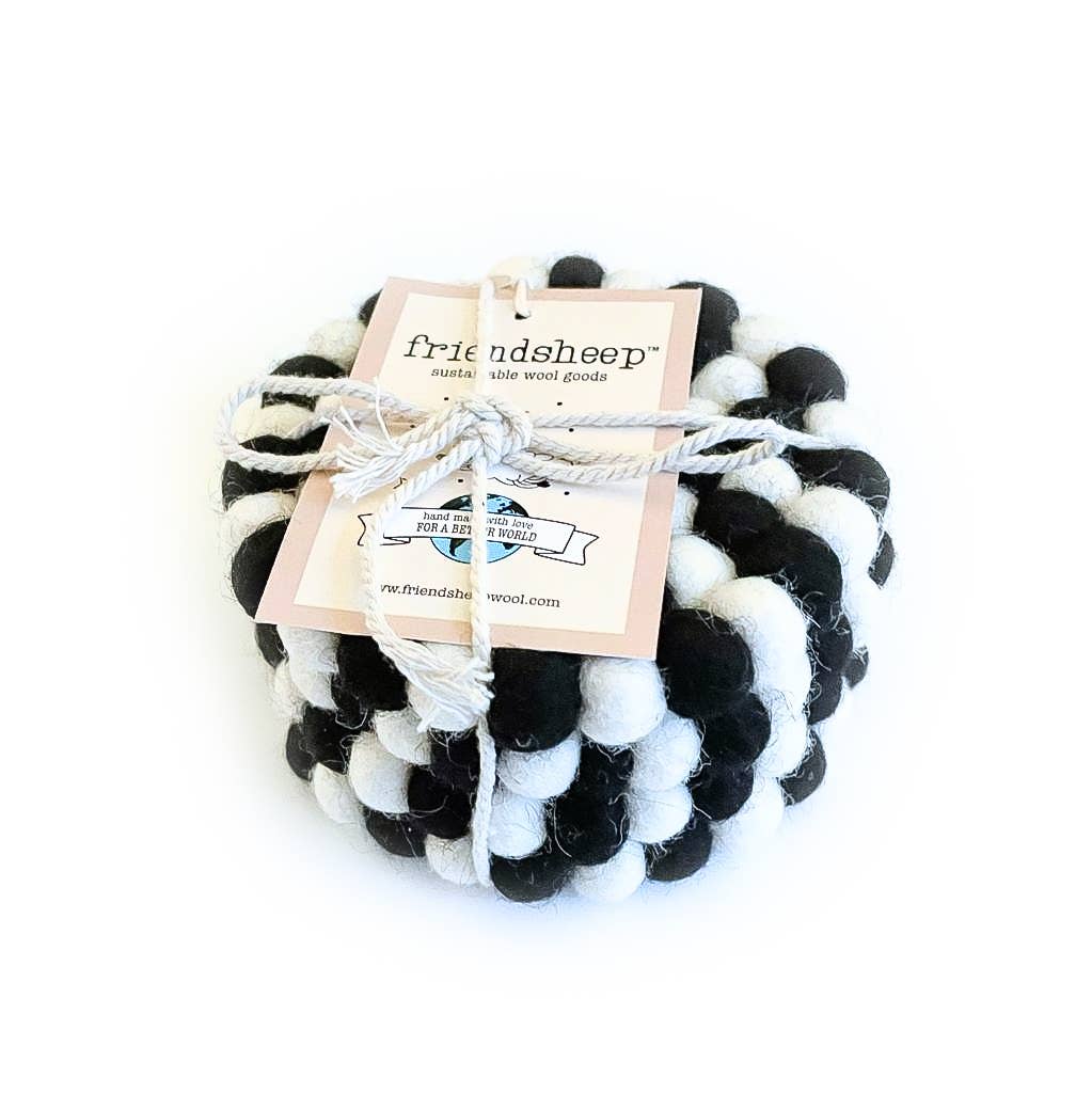 Set of four black and white coasters with a 'friendsheep' label on a white background