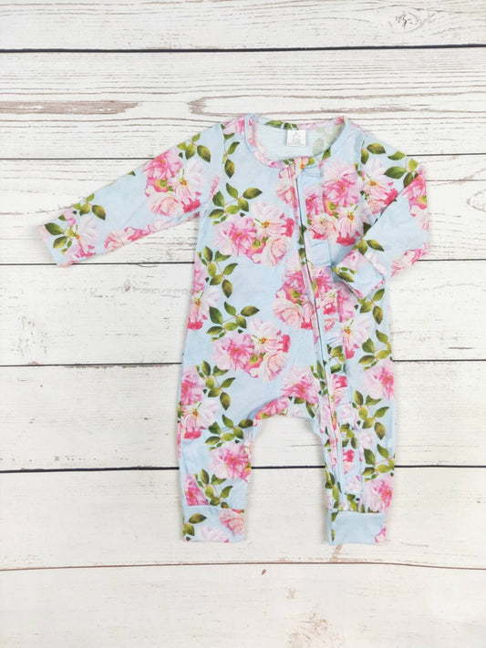 Floral baby onesie on a wooden surface