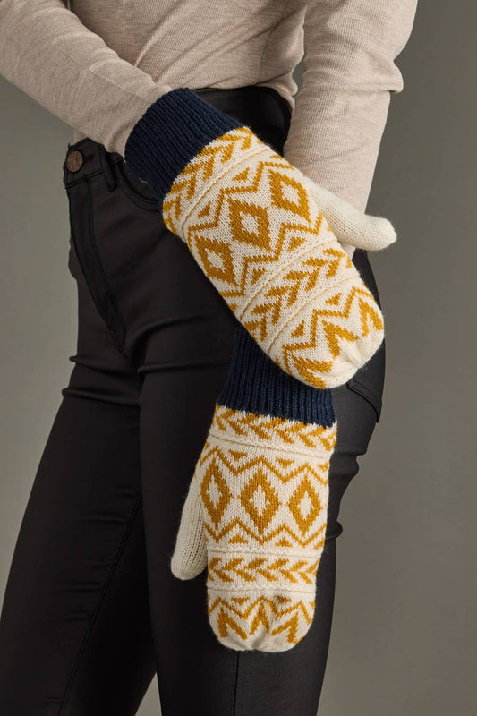 Person wearing patterned mittens with a neutral background