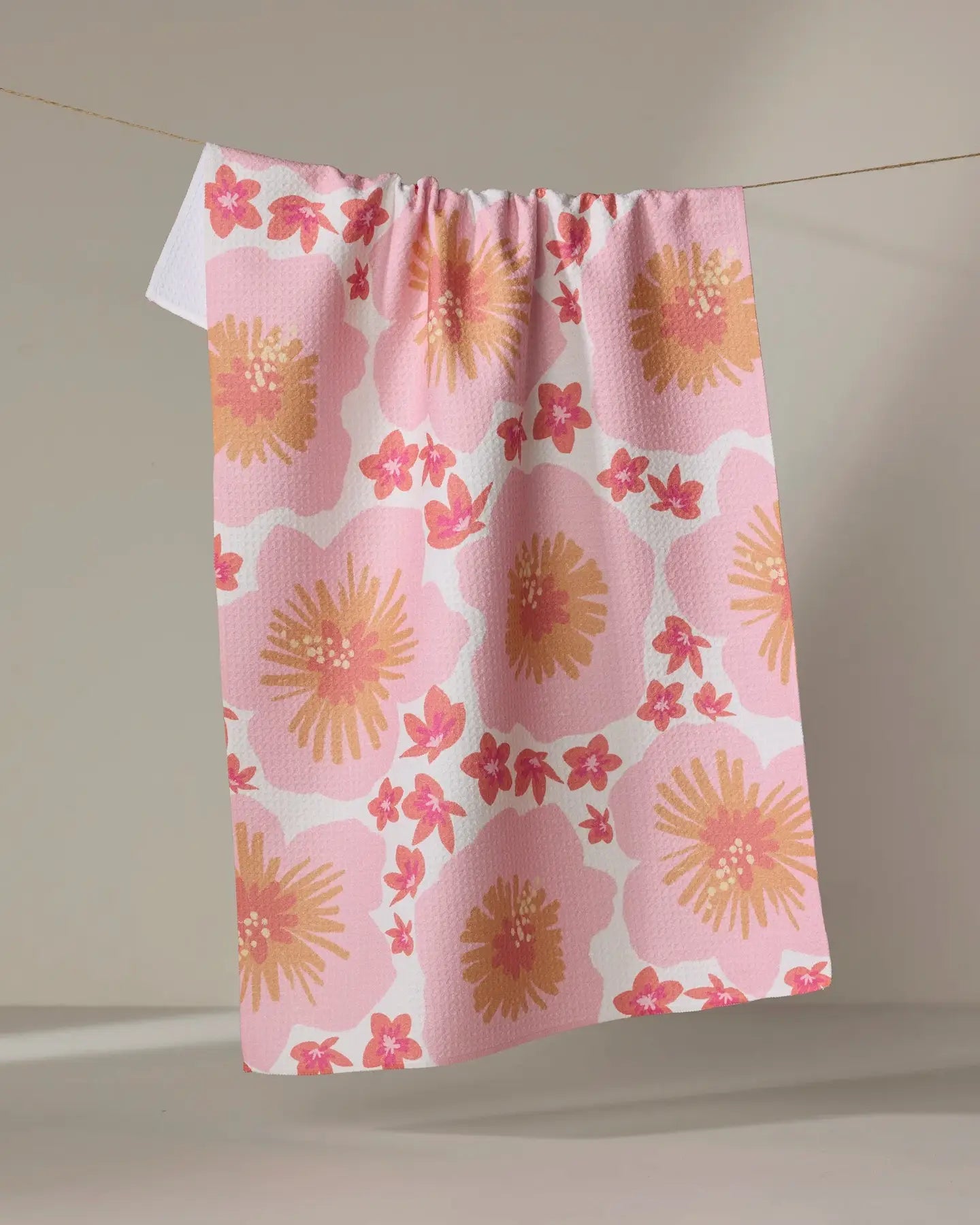 Floral-patterned Geometry tea towel hanging on a line against a neutral background