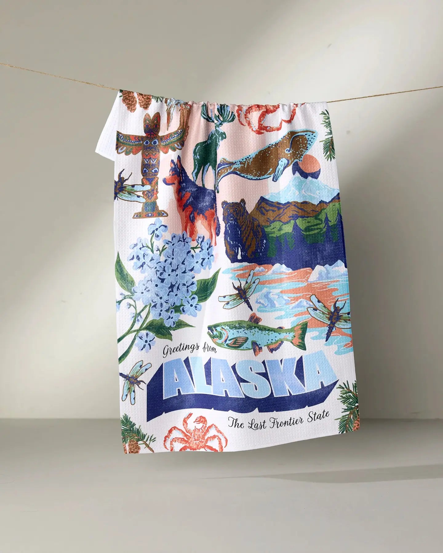 Colorful Geometry tea towel with Alaska-themed design featuring animals and nature on a white background.