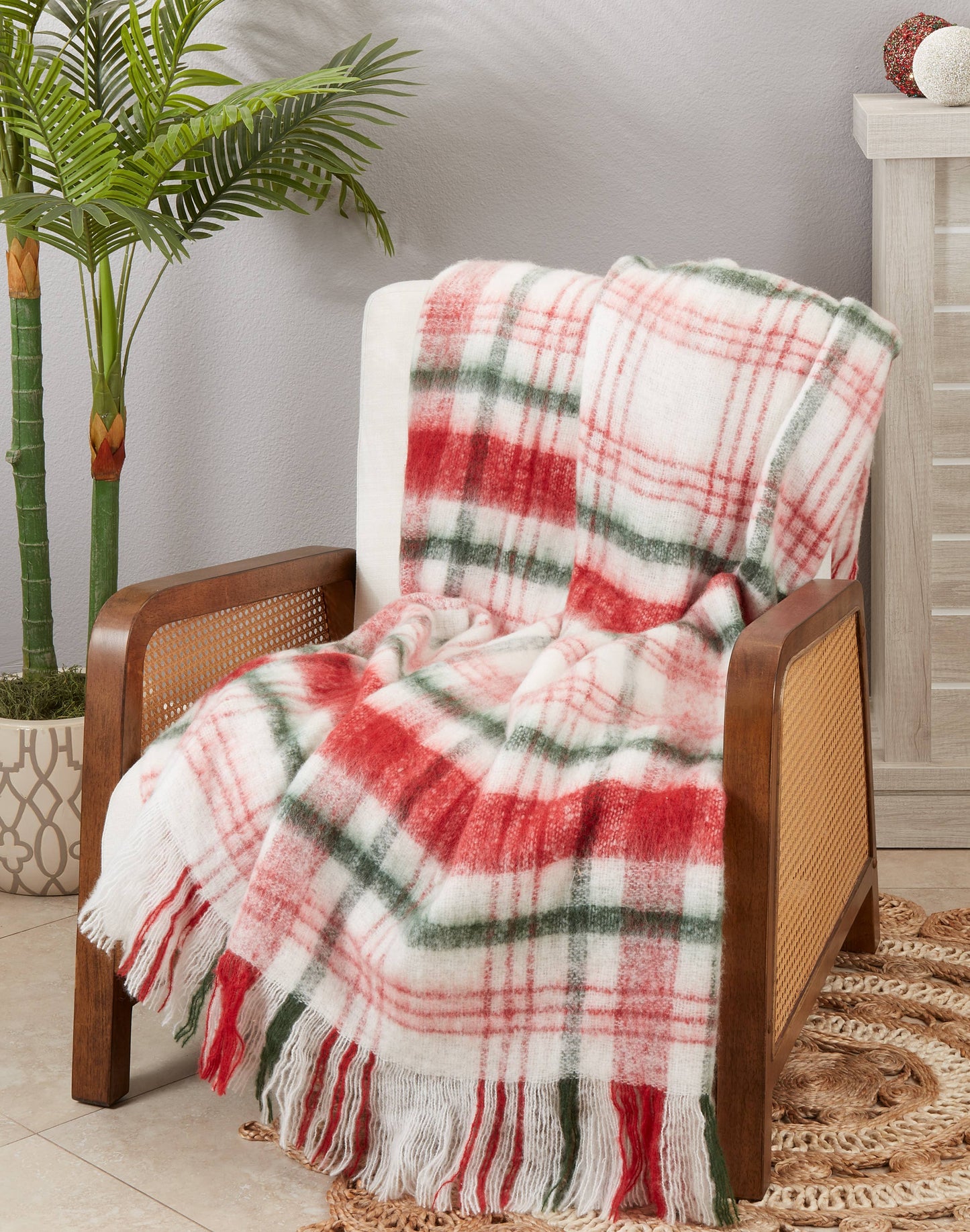 Faux Mohair plaid blanket draped over a wooden chair with a plant and side table in the background.
