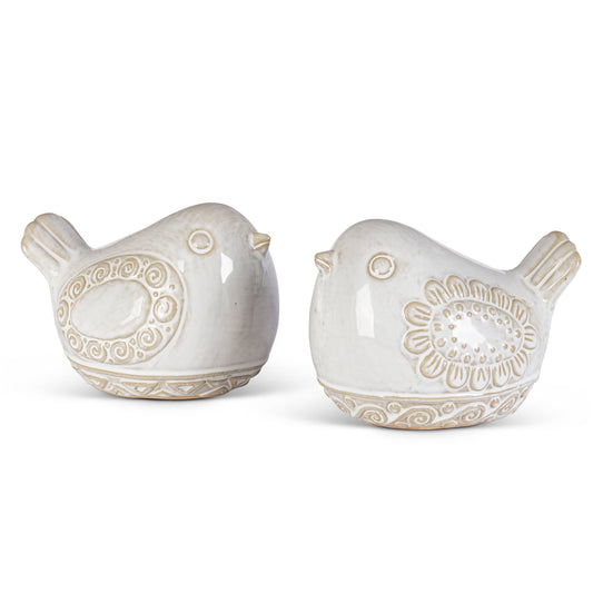 Two white ceramic bird figurines with decorative patterns on a white background