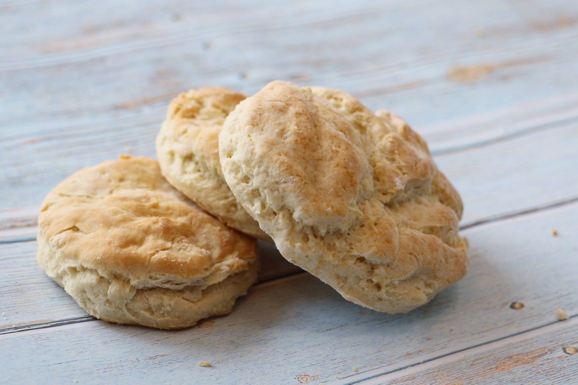 Three biscuits stacked on a wooden surface