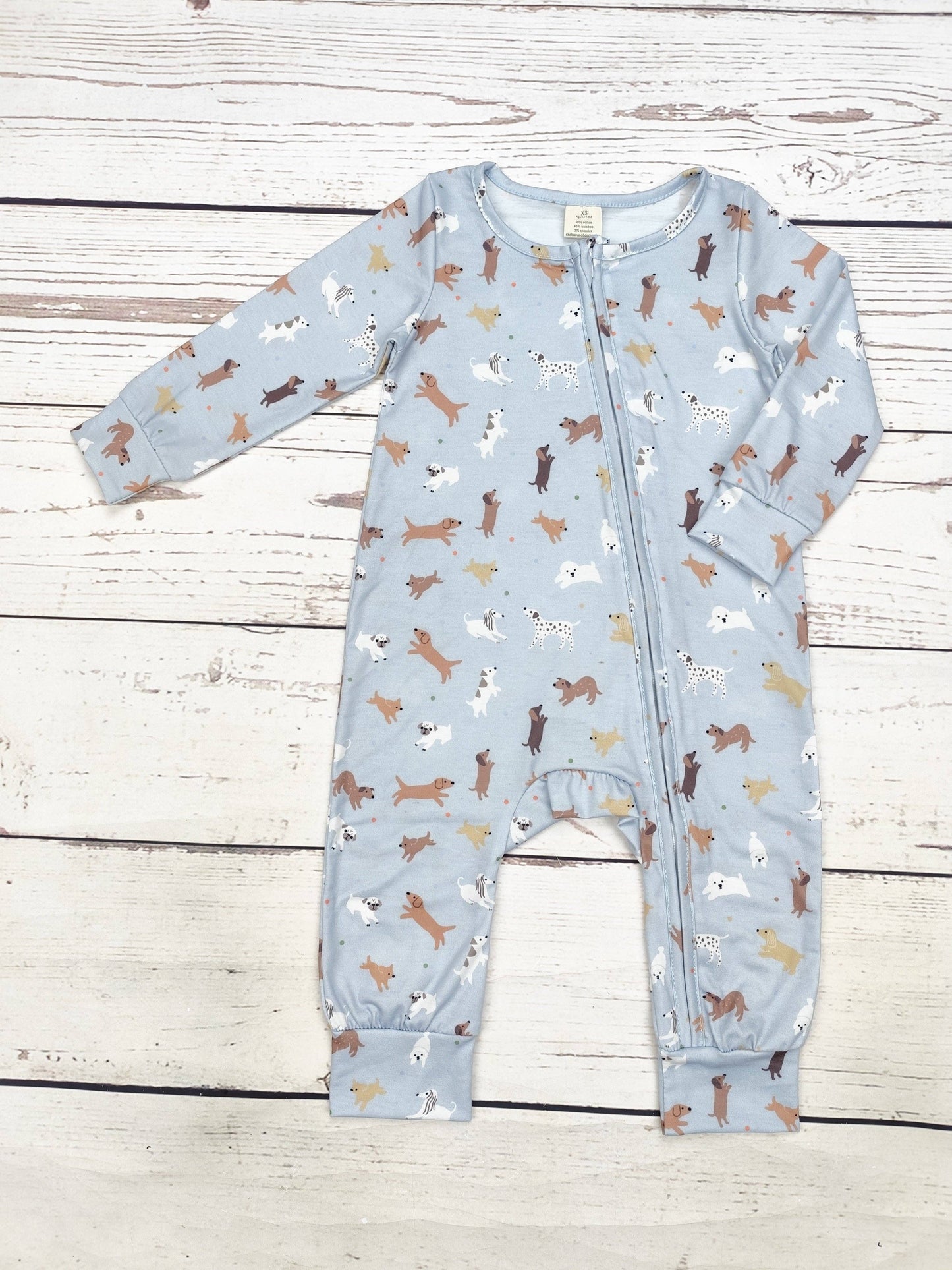 Baby onesie with dog pattern on a wooden surface