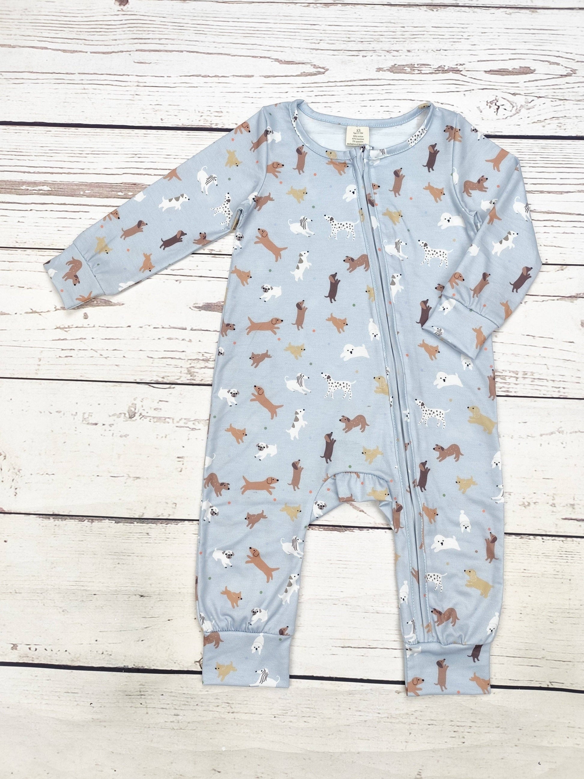 Baby onesie with dog pattern on a wooden surface