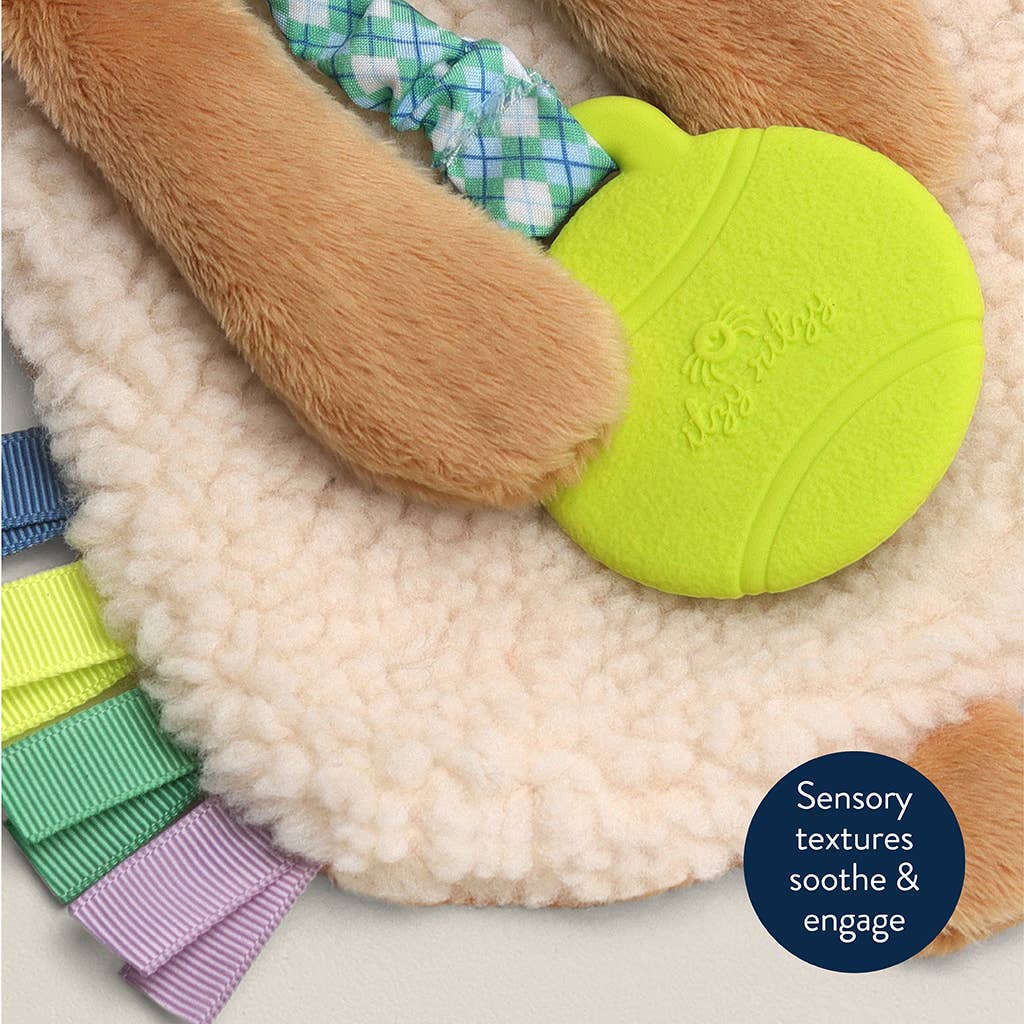 Dog toy with green textured ball and plaid ribbon, on a soft surface.