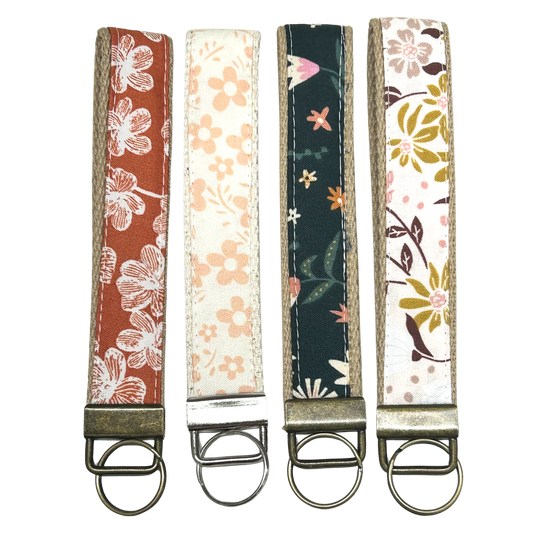 Four floral-patterned keychains on a white background