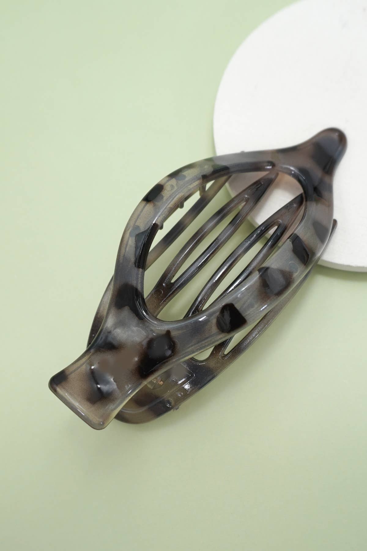 Havana tortoiseshell hair clip on a light green background