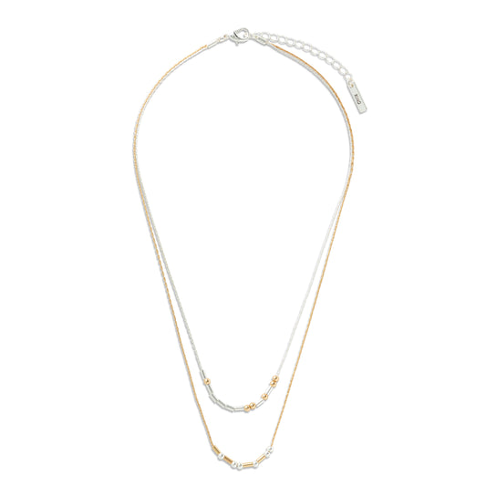 A double-strand necklace featuring one fine gold chain and one fine silver chain, both adorned with small polished bead accents near the bottom, displayed on a clean white background, beads spell out you're kind in morse code
