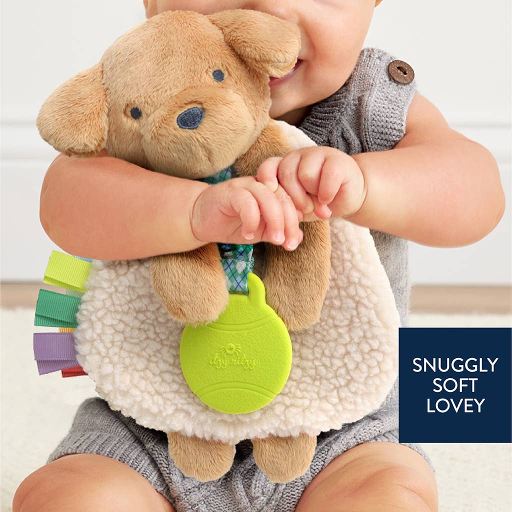 Child holding a soft toy with colorful elements and text 'Snuggly Soft Lovey' on a light background