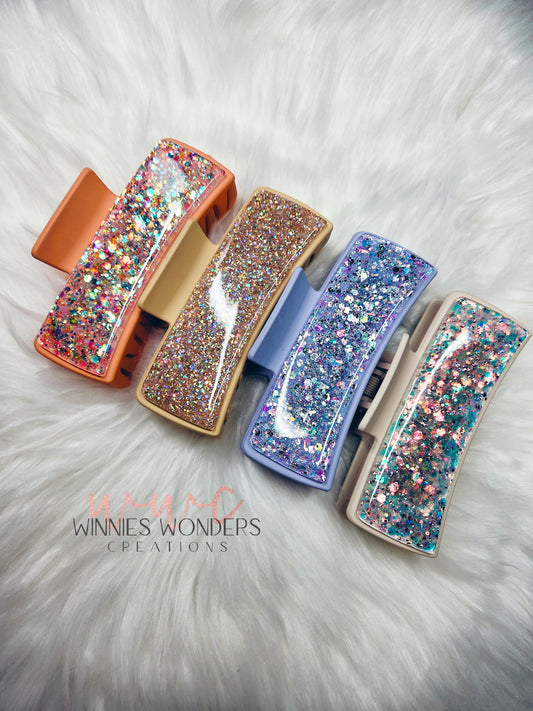 Winnies Wonders Creations Hair Clips of peach, tan, periwinkle and cream with multicolor glitters on a white fur background