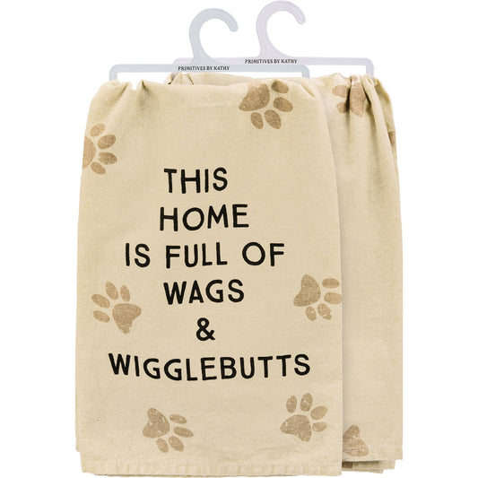 Beige towel with paw prints and text 'This home is full of wags & wigglebutts' on a white background