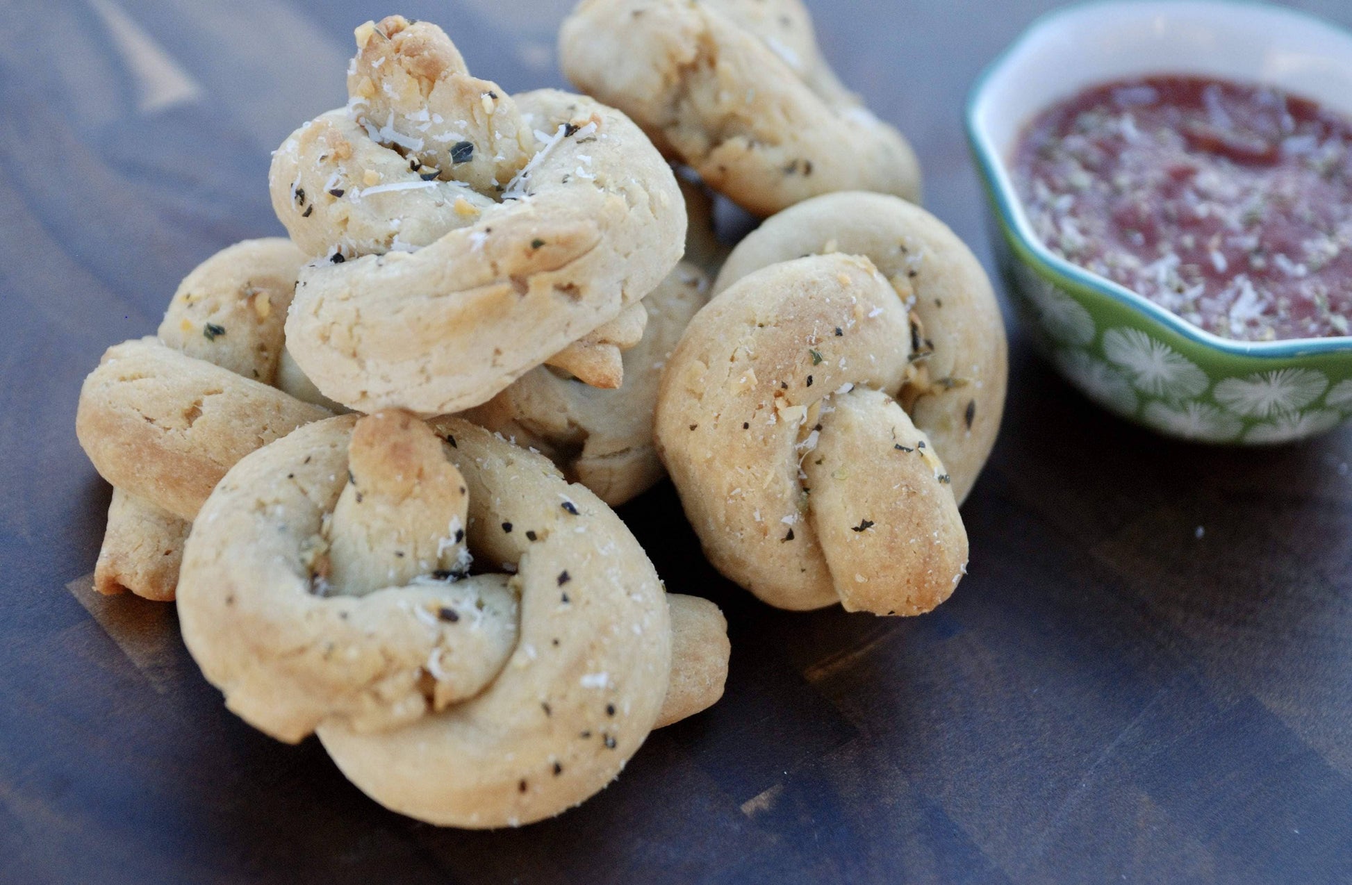 Bread rolls with a dipping sauce on a wooden surface