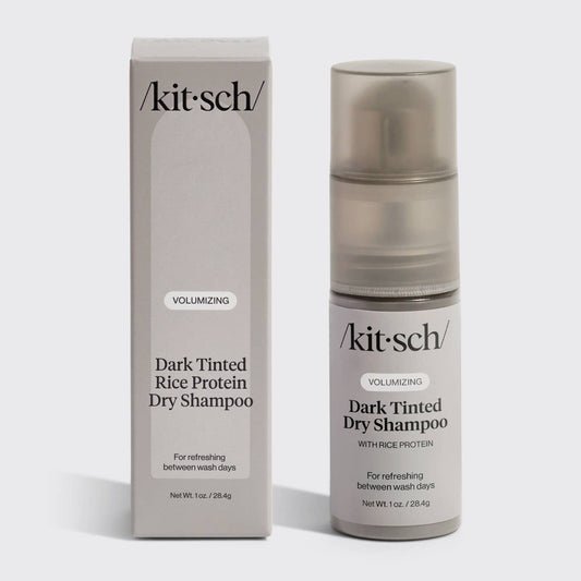 A packaged and pump bottle of Kitsch Volumizing Dark Tinted Rice Protein Dry Shampoo, indicating it is for refreshing between wash days.