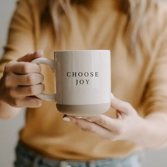 Person holding a mug with 'CHOOSE JOY' text
