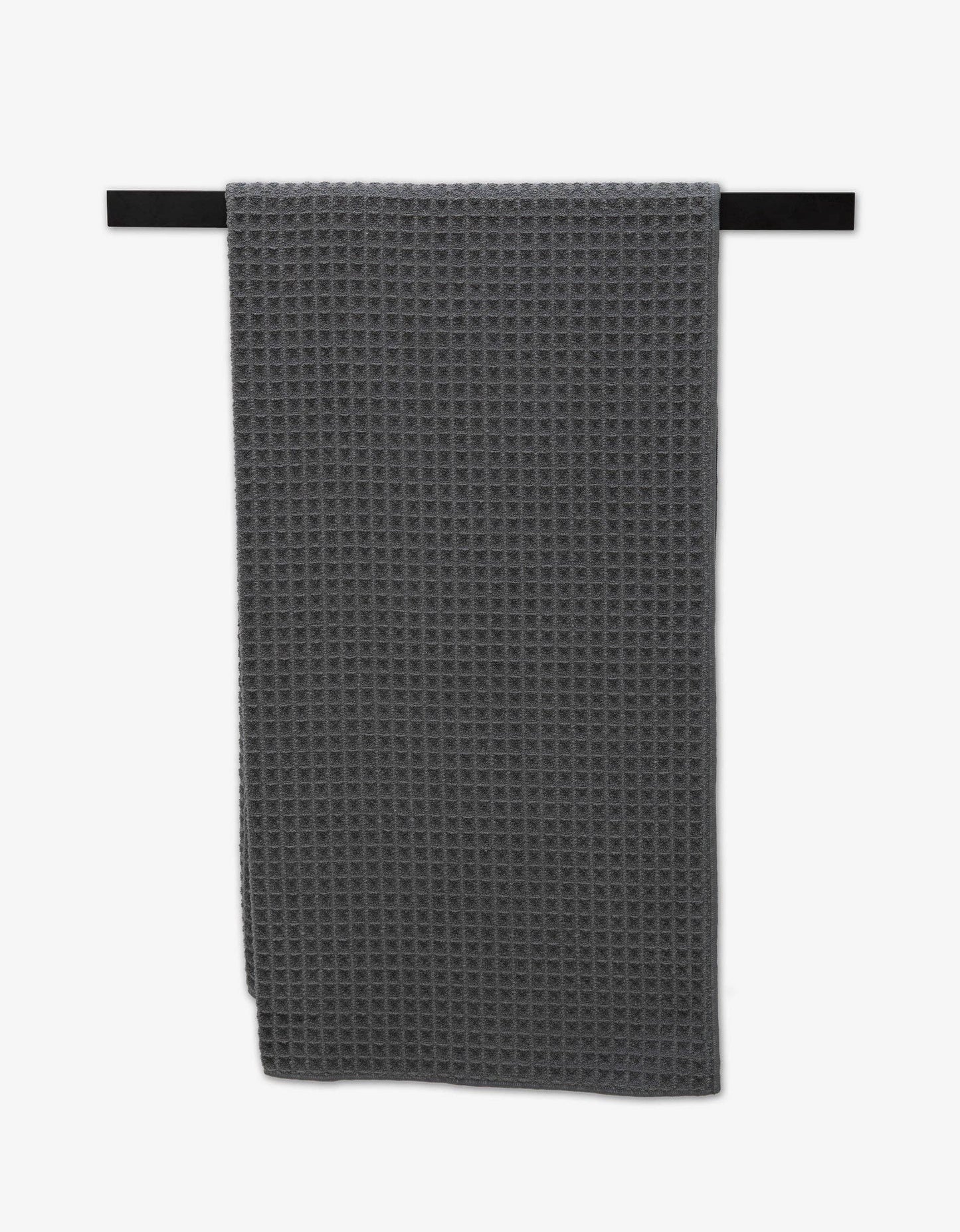 Geometry Waffle Bath Towel Charcoal Gray waffle-textured towel hanging on a black rod against a white background