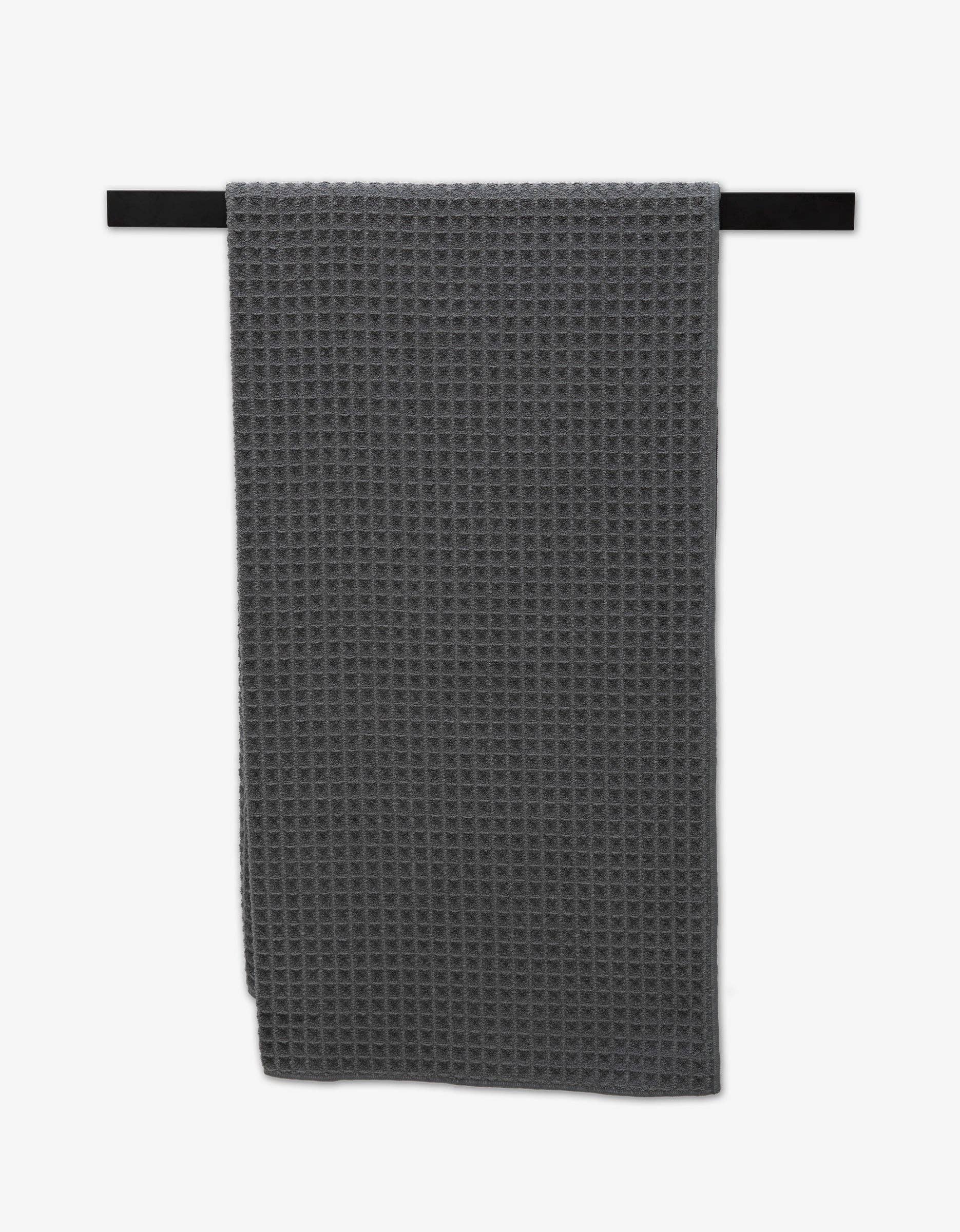 Geometry Waffle Bath Towel Charcoal Gray waffle-textured towel hanging on a black rod against a white background