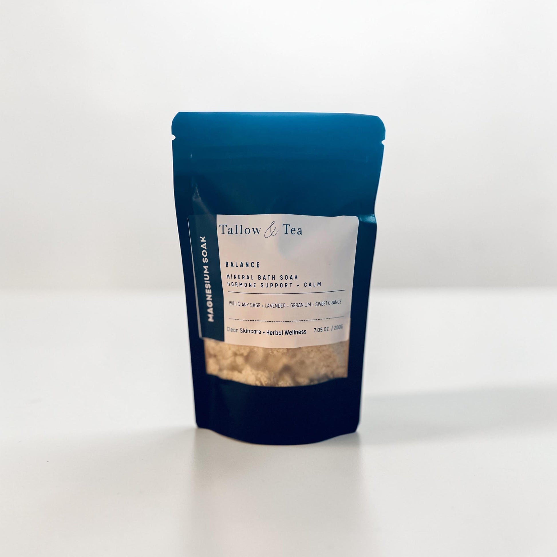 Black package of Tallow & Tea Mineral bath soak with a white label on a white background
