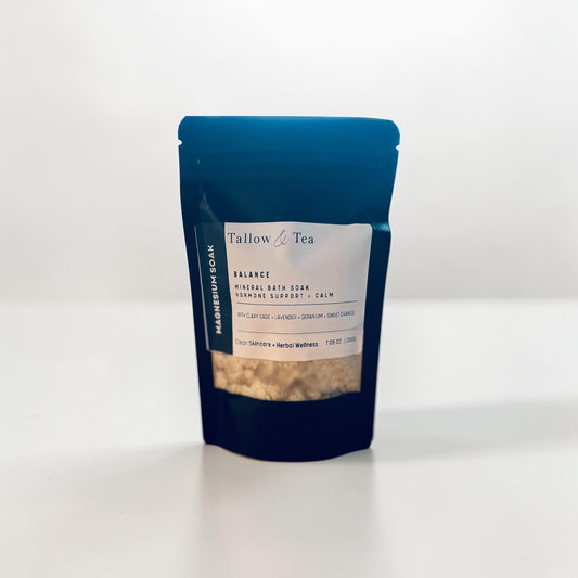 Black package of Tallow & Tea Mineral bath soak with a white label on a white background