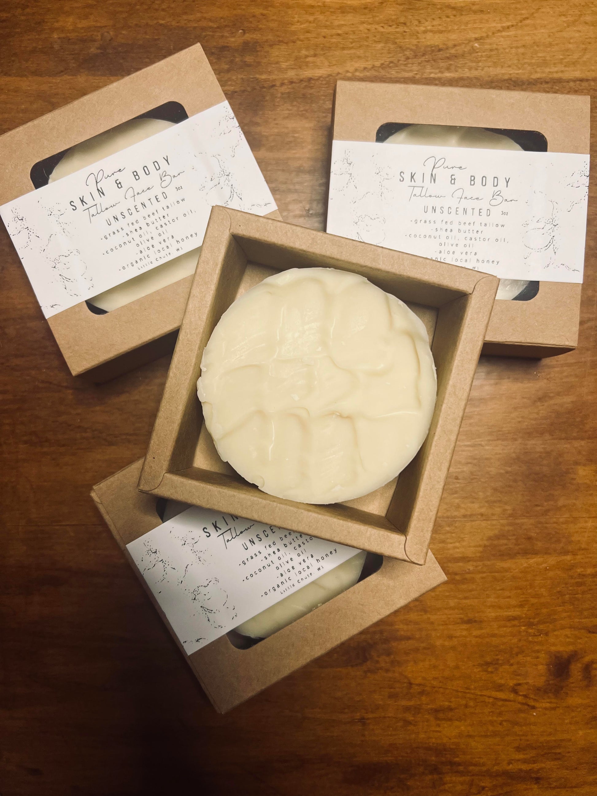 Three bars of soap in cardboard boxes on a wooden surface, with 'Skin & Body' labels.