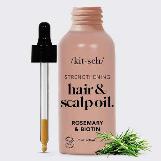 Kit'sch hair and scalp oil bottle with dropper and rosemary leaves on a light gray background