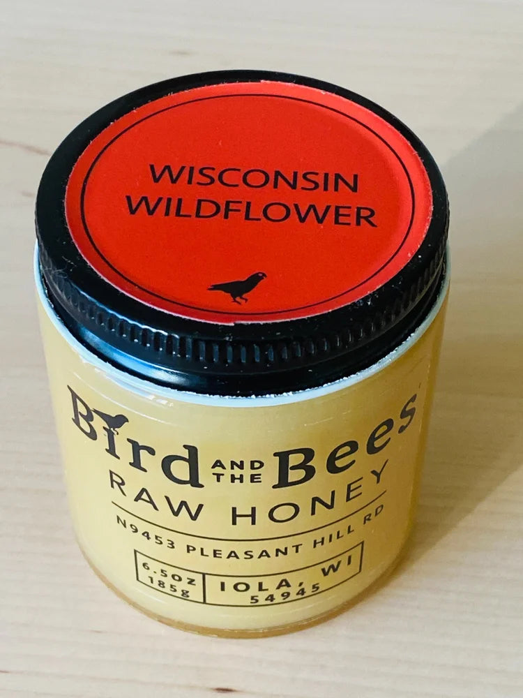 Jar of Bird and The Bees Raw Honey with 'Wisconsin Wildflower' lid on a light background