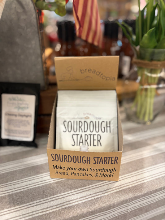Sourdough Starter package on counter with striped tablecloth and flowers in the background