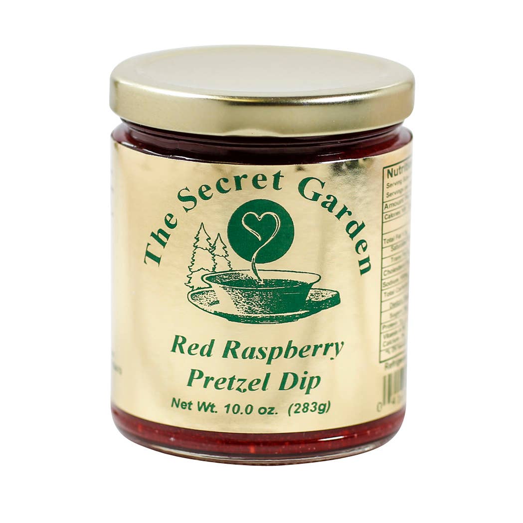 A glass jar of The Secret Garden Red Raspberry Pretzel Dip with a gold metal lid and a cream-colored label with green text and graphics, set against a plain white background.