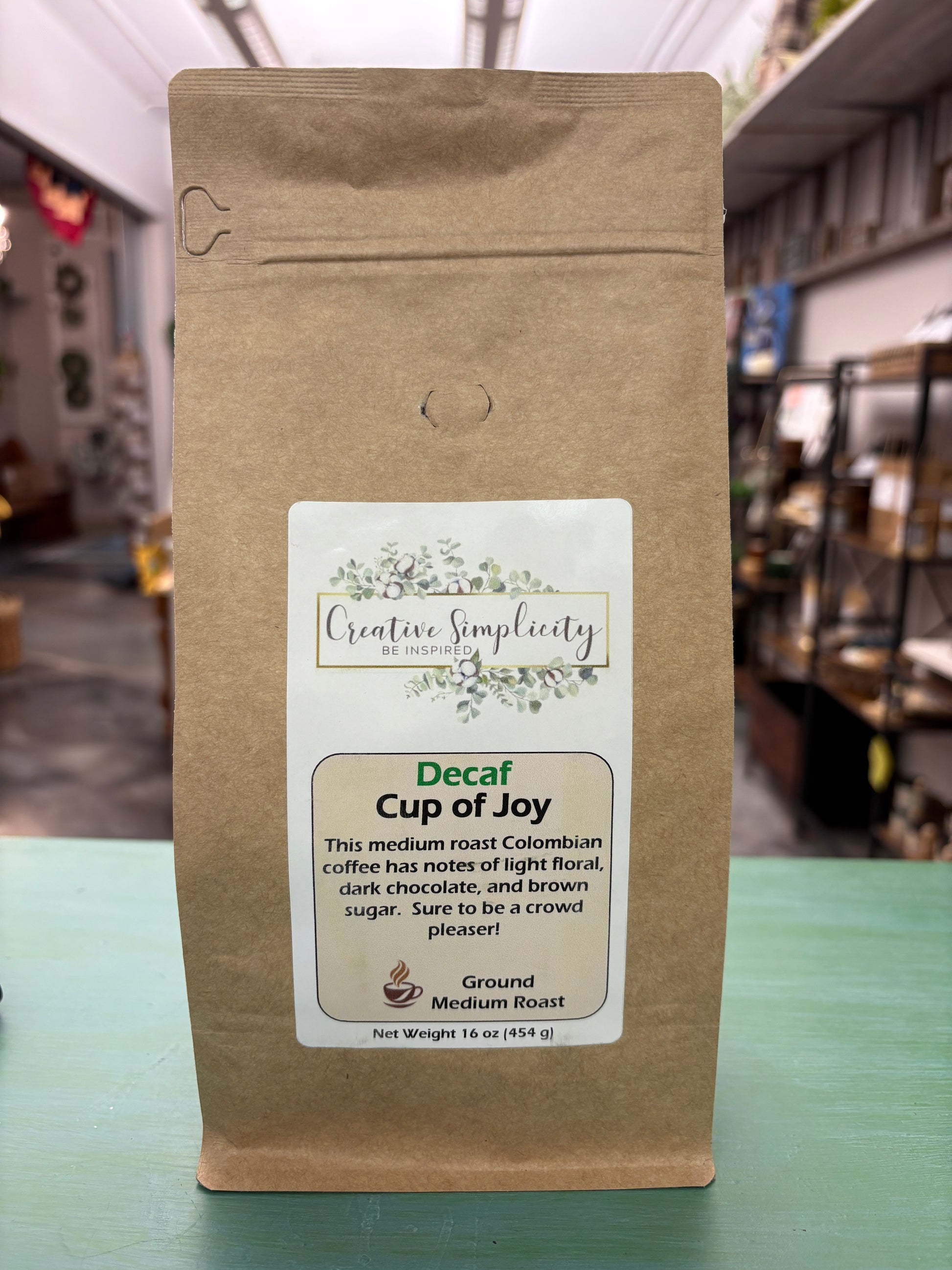 Decaf coffee package with a Cup of Joy label on a blurred background