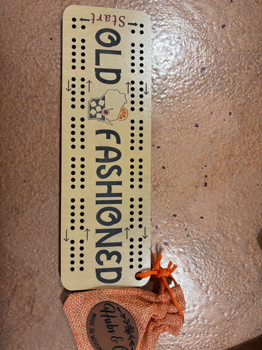 Cribbage board with 'Old Fashioned' design on a textured surface