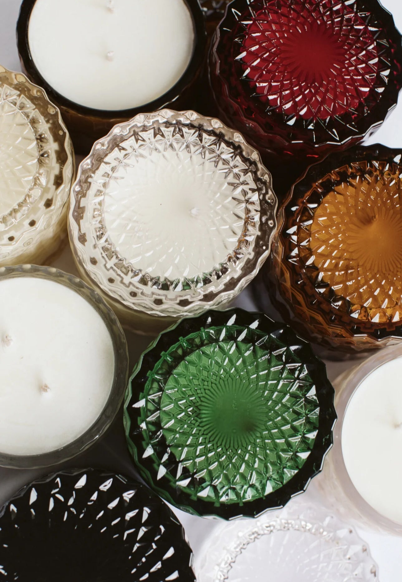assortment of glass vessels with pure soy wax candles on white background