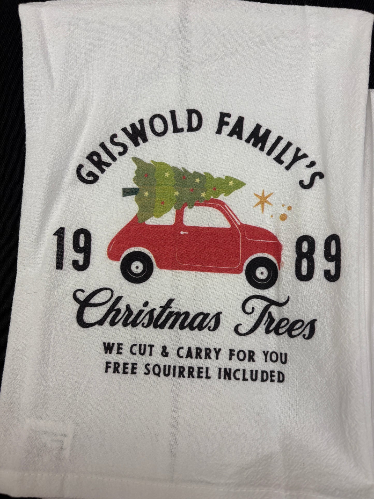 Christmas Vacation Tea Towel White towel with red truck and Christmas tree design, featuring text about Christmas trees and a year.