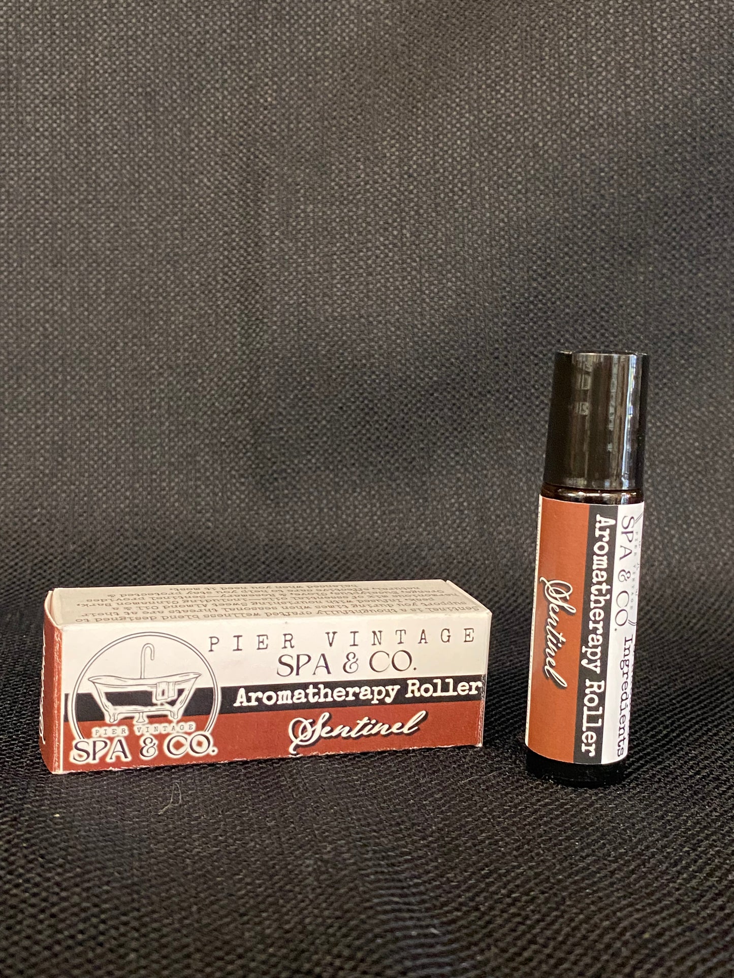 Aromatherapy roller and its packaging on a textured surface