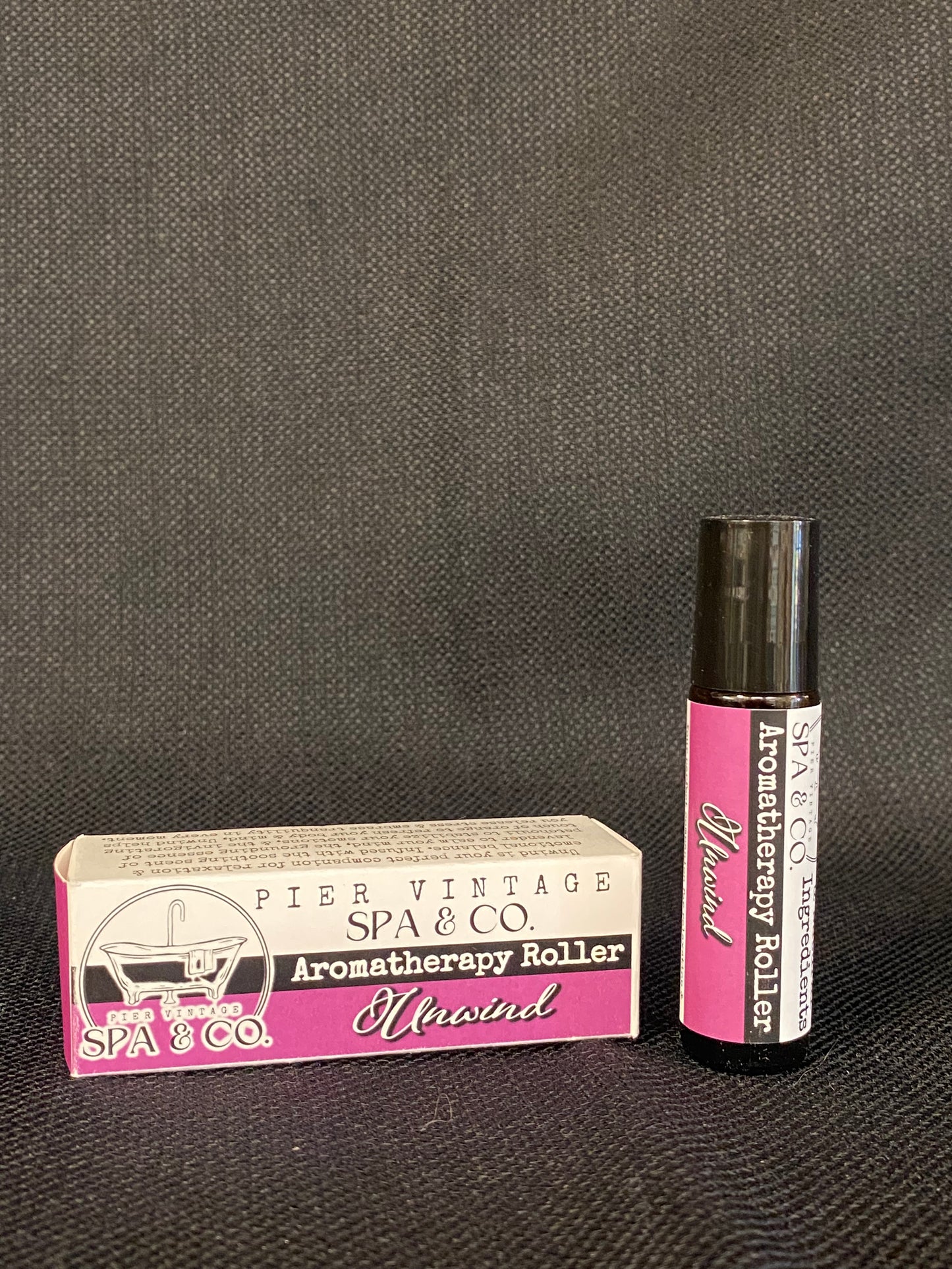 Aromatherapy roller and its packaging on a textured surface