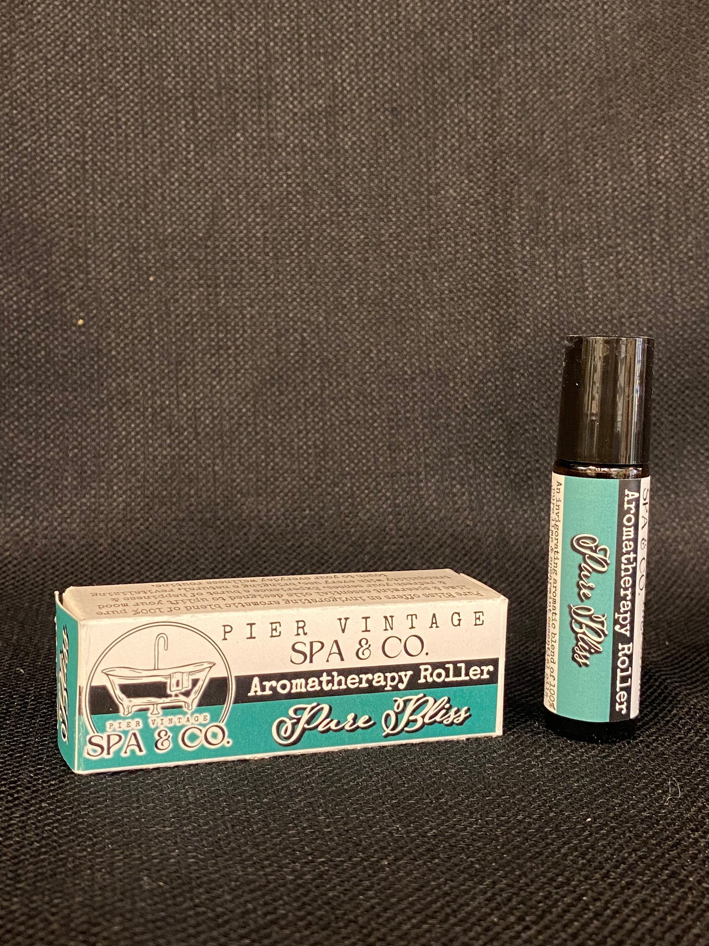 Aromatherapy roller and its packaging on a textured surface