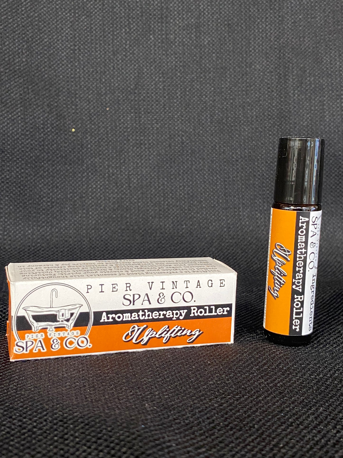 Aromatherapy roller and its packaging on a textured surface