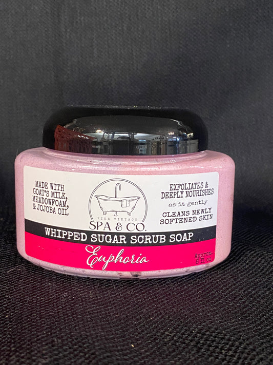 Jar of whipped sugar scrub soap with a pink and white label on a textured black surface from Pier Vintage Spa & Co.