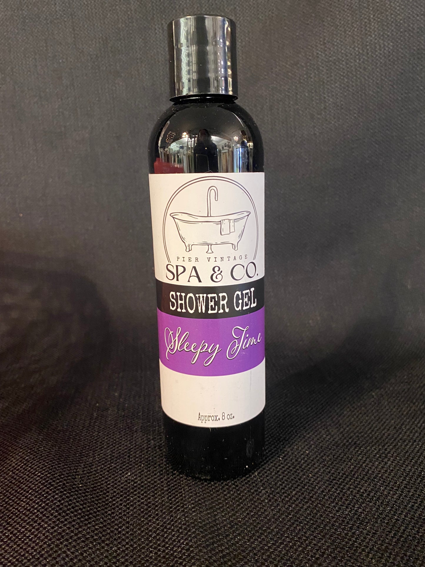 Bottle of Sleepy Time shower gel with a label on a dark background by Pier Vintage Spa & Co.