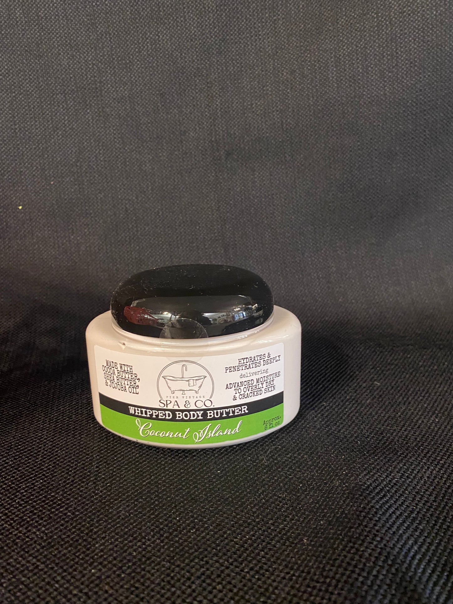 Container of Whipped Body Butter called Coconut Island by Pier Vintage Spa & Co. on a dark textured surface