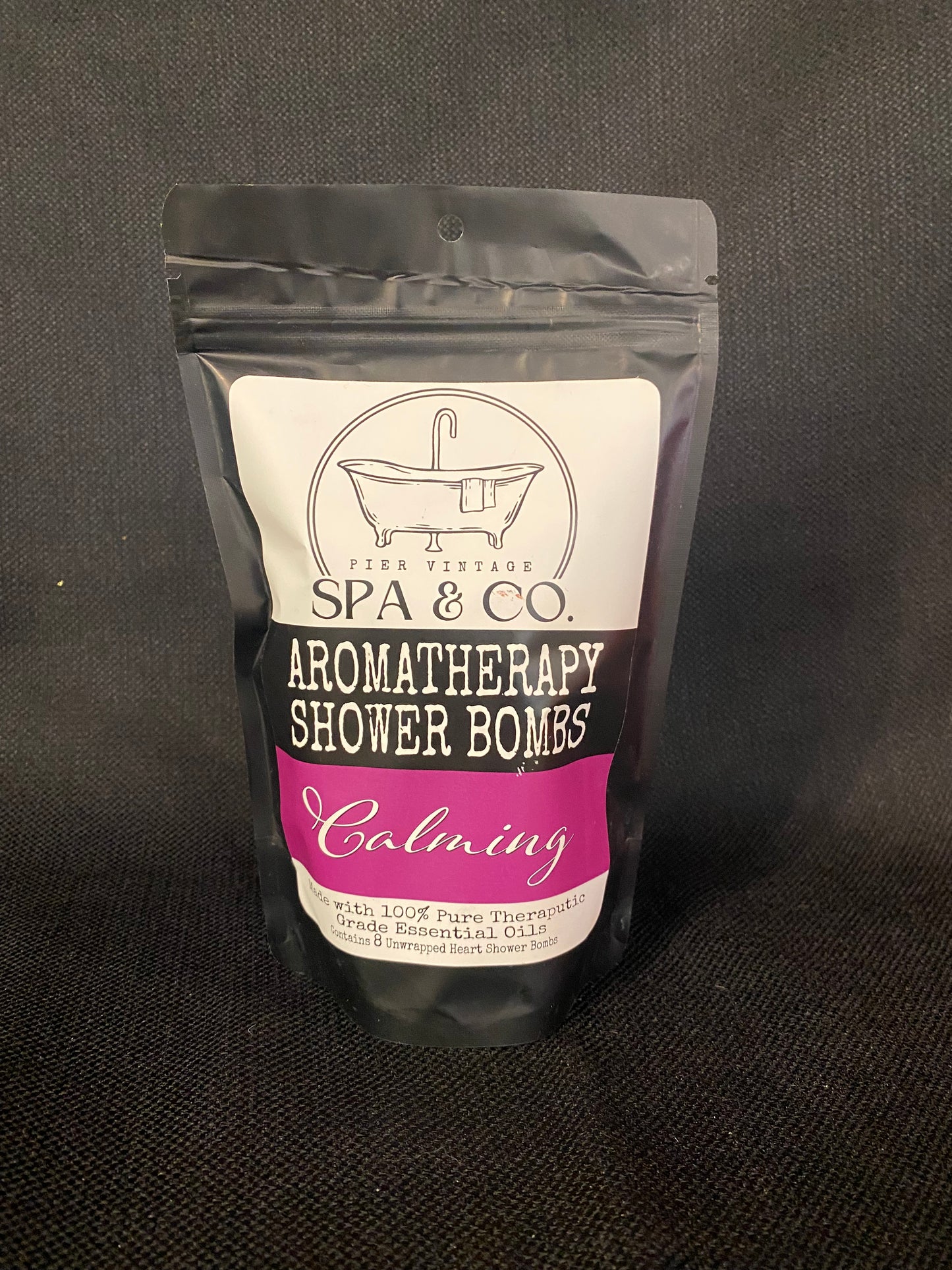 Packaged aromatherapy shower bomb with Pier Vintage Spa & Co branding on a dark background