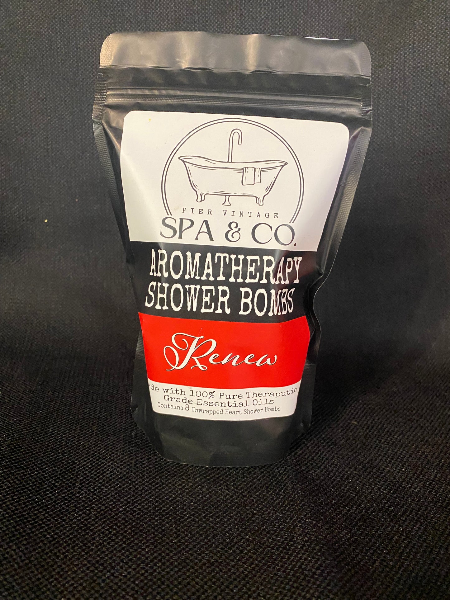 Packaged aromatherapy shower bomb with Pier Vintage Spa & Co branding on a dark background
