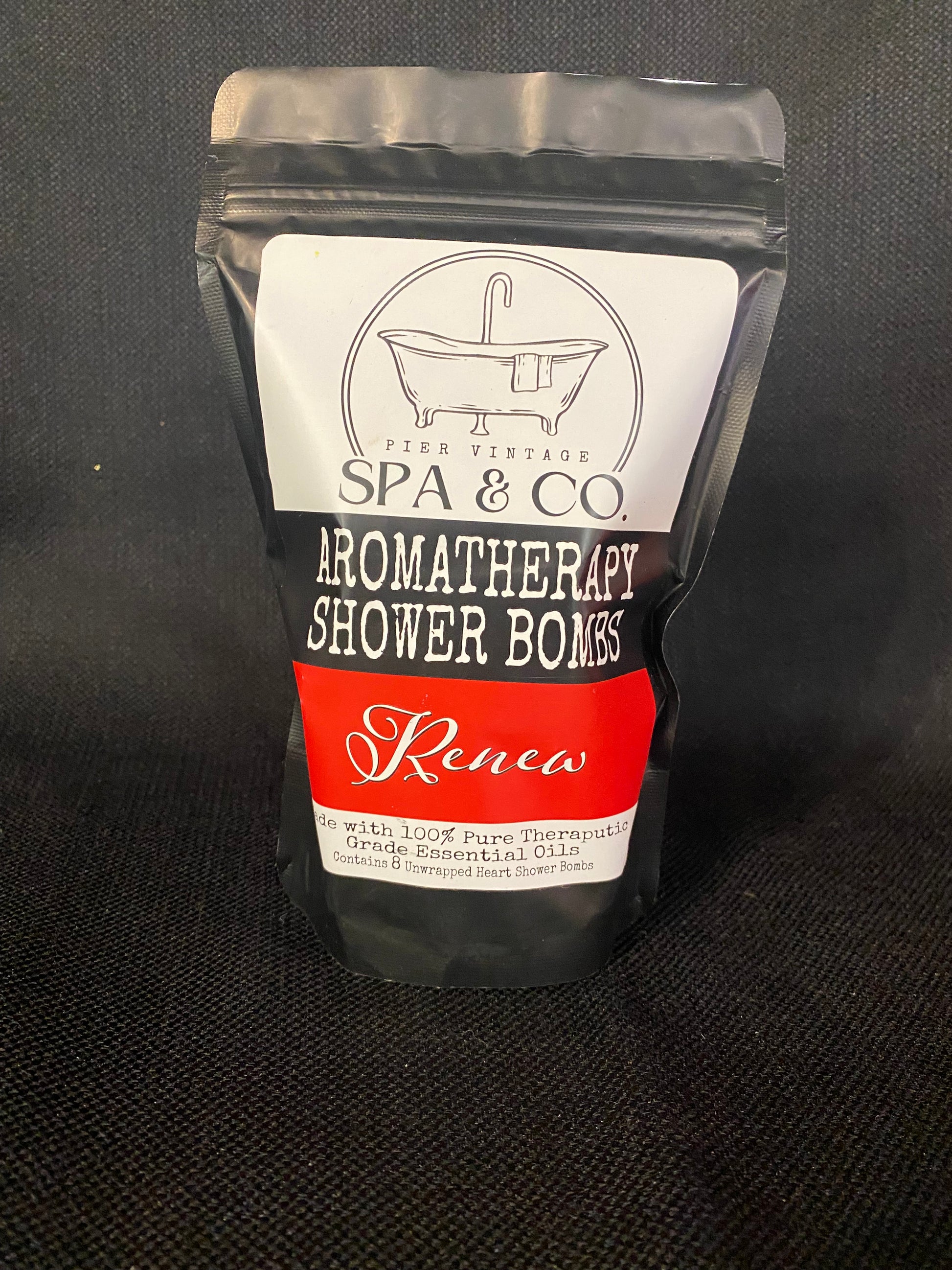 Packaged aromatherapy shower bomb with Pier Vintage Spa & Co branding on a dark background