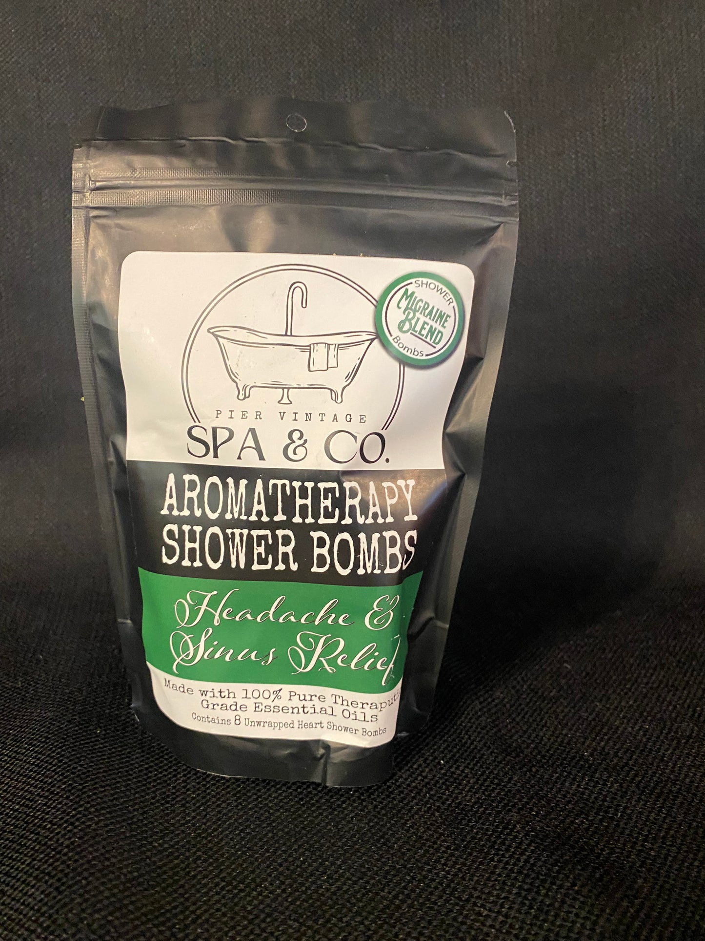 Packaged aromatherapy shower bomb with Pier Vintage Spa & Co branding on a dark background