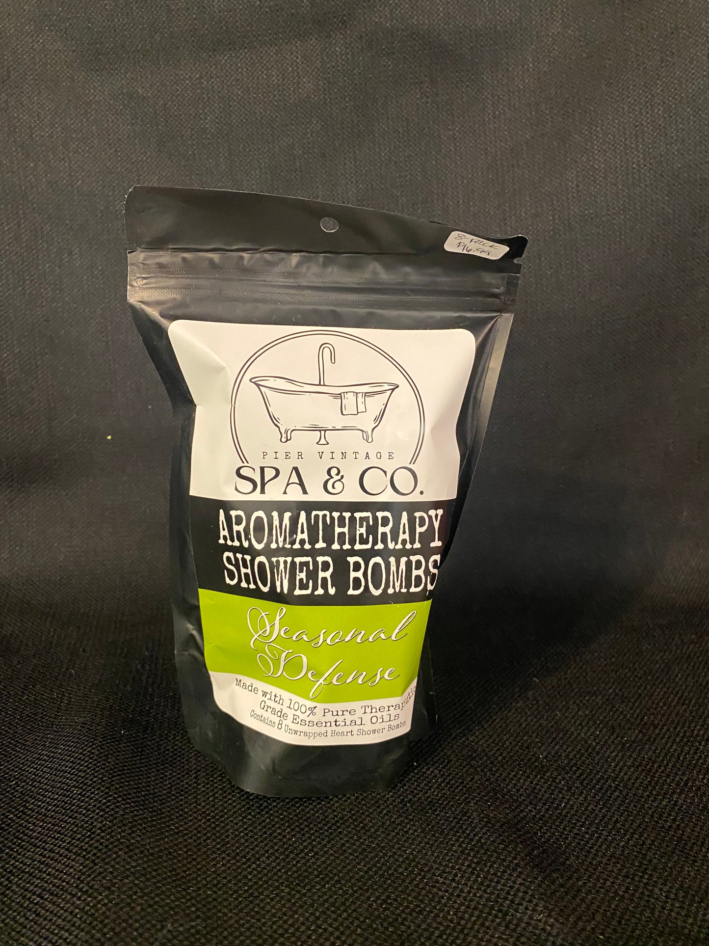 Packaged aromatherapy shower bomb with Pier Vintage Spa & Co branding on a dark background