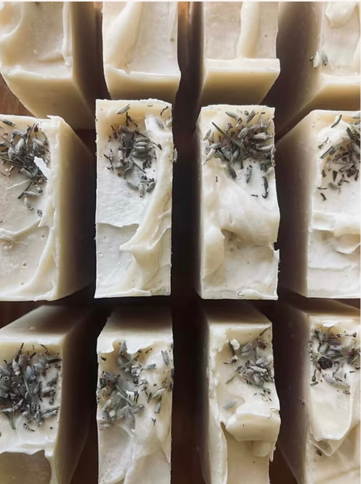 Close-up of soap bars with visible herbs in a grid pattern