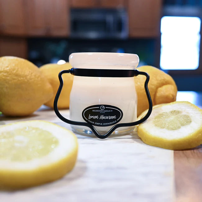 Jar of lemon scented candle with lemons on a wooden surface