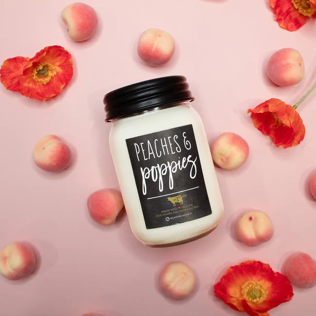 Jar of 'Peaches & Poppies' candle on a pink background with peaches and poppies.
