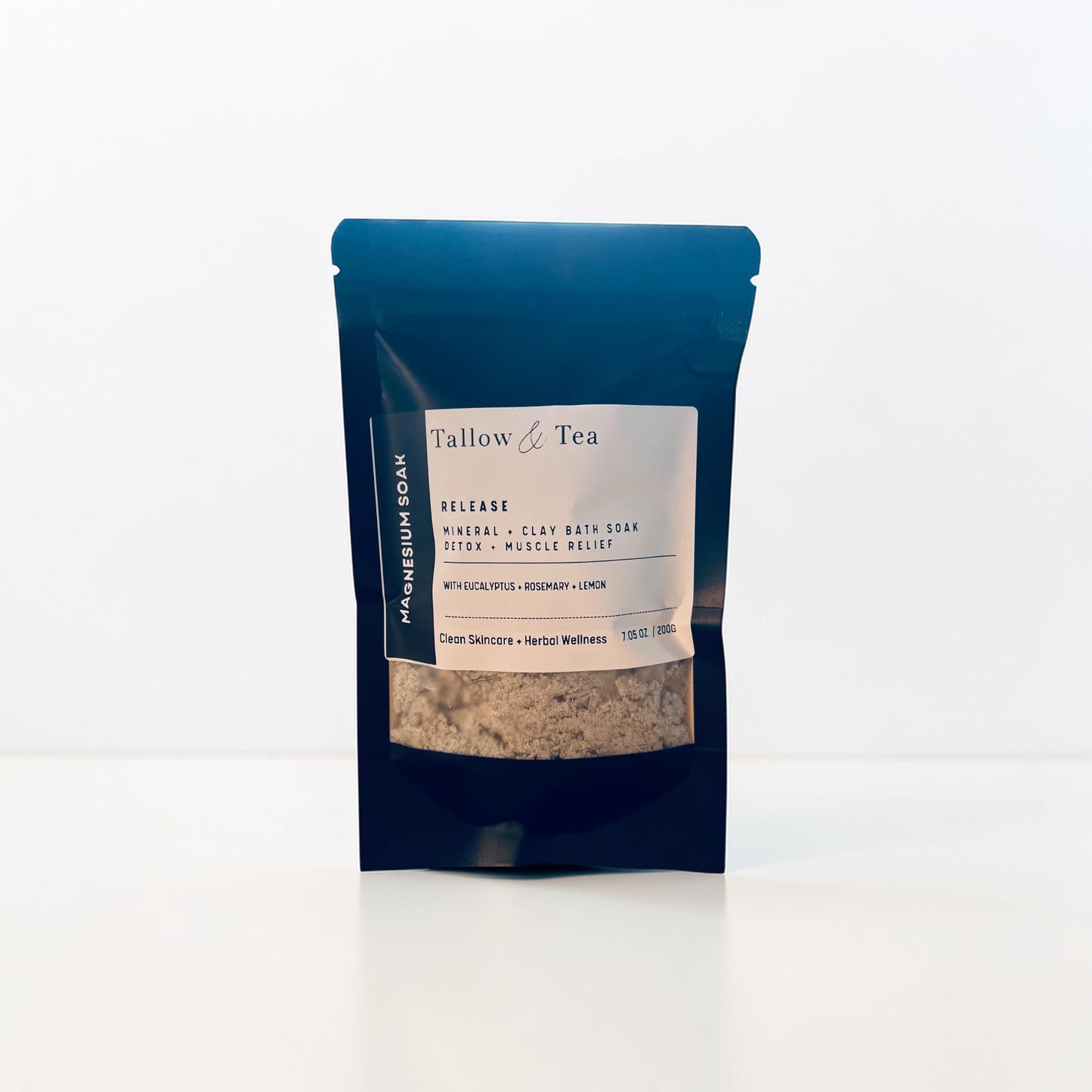 Black package of Tallow & Tea Mineral bath soak with a white label on a white background